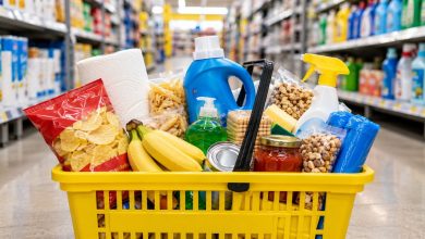 Shopping basket filled with discounted household items and snacks in a bright discount store aisle