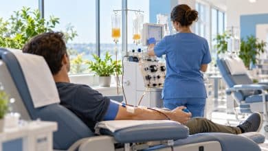 Adult donor relaxing in a reclining chair during a plasma donation at a bright, modern donation center