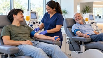 Young adult and older adult donating plasma side by side in reclining chairs at a bright donation center