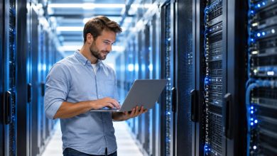 Technician with a laptop in a bright data center aisle lined with server racks